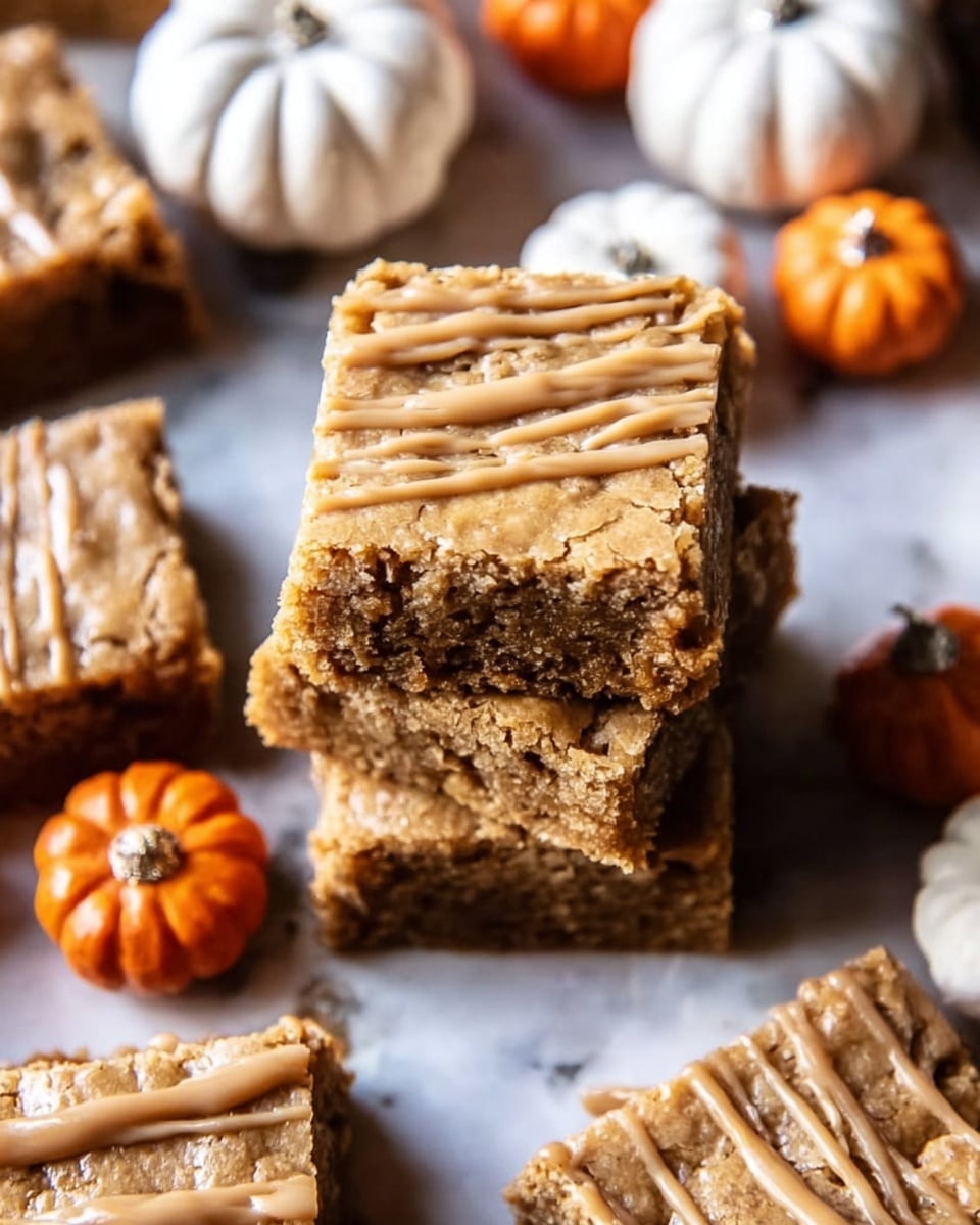 The image shows a stack of two light brown dessert bars with a crumbly texture, topped with thin drizzles of light caramel-colored icing. Around the stack are several more dessert bars, each with the same crumbly top and caramel drizzle. The bars are placed on a wooden surface, surrounded by small white pumpkins and orange mini pumpkins, creating an autumn feel. photo taken with an iphone --ar 4:5 --v 7
