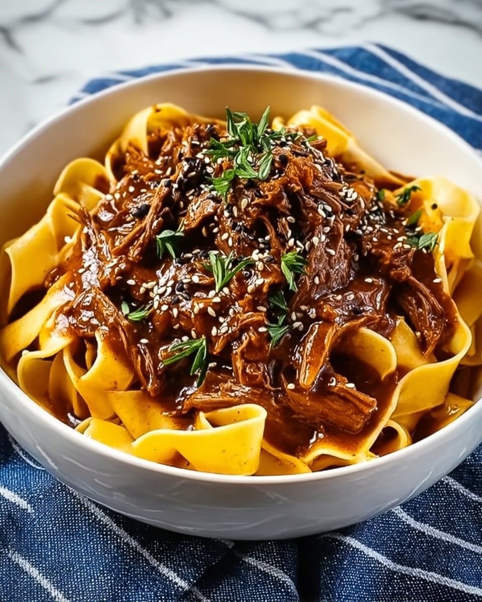 A white bowl with a layer of wide, flat pale yellow pasta at the bottom, topped with a thick, dark brown shredded meat stew. The meat looks tender and juicy, covered in a rich sauce with a glossy texture. The stew is garnished with fresh green parsley leaves and small black and white sesame seeds, adding color contrast. The bowl is set on a white marbled surface with a blue-striped cloth partially visible on one side. photo taken with an iphone --ar 4:5 --v 7