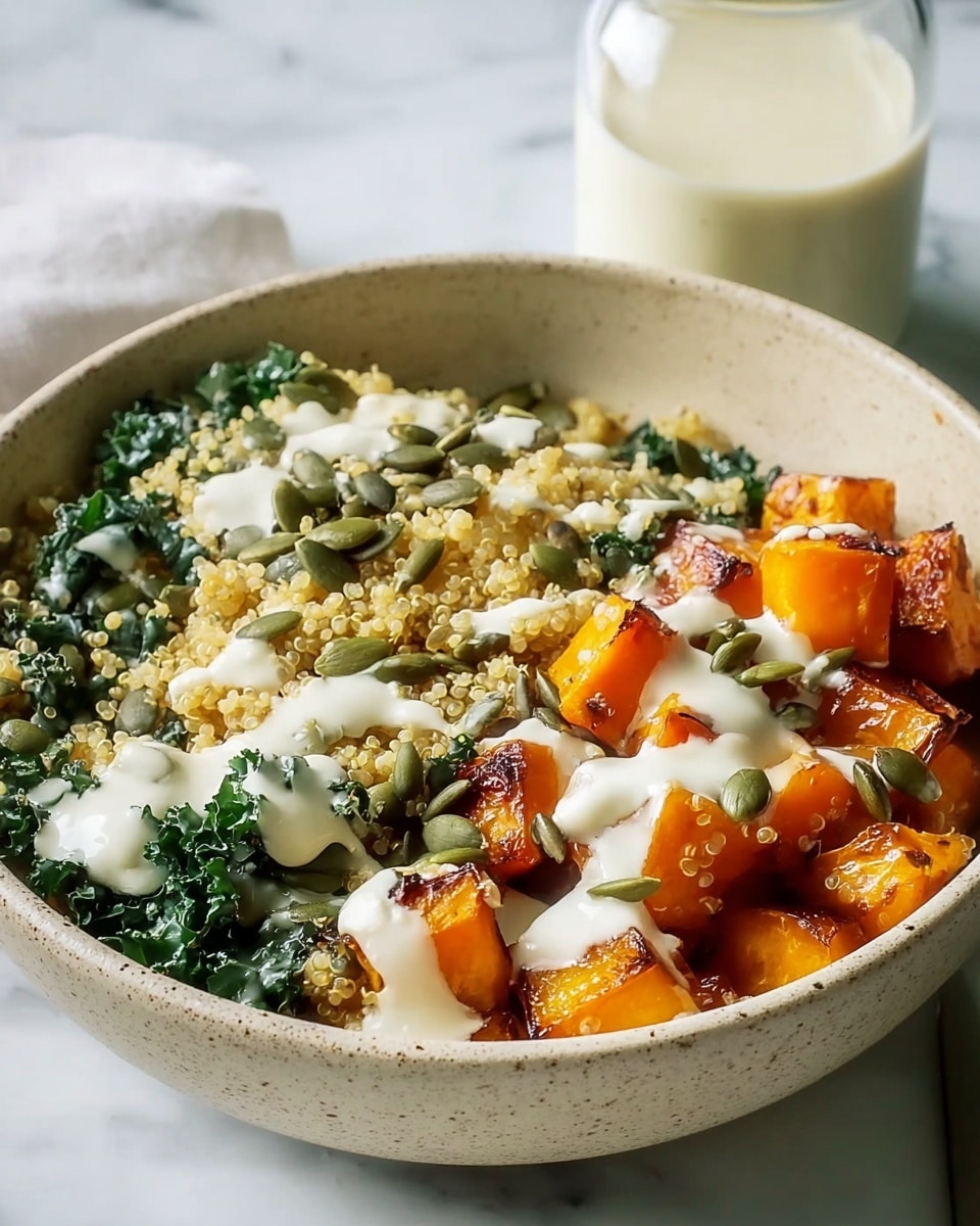 The dish is served in a white speckled bowl filled with three main layers: at the bottom, there are bright orange roasted sweet potato cubes with a slightly charred texture; on top of that is a layer of fluffy, pale yellow quinoa mixed with fresh, deep green kale leaves; scattered across the surface are light green pumpkin seeds adding texture; the whole bowl is drizzled with a creamy white sauce flowing lightly over the ingredients; in the background, a glass jar with a creamy liquid sits on a white marbled surface. Photo taken with an iphone --ar 4:5 --v 7