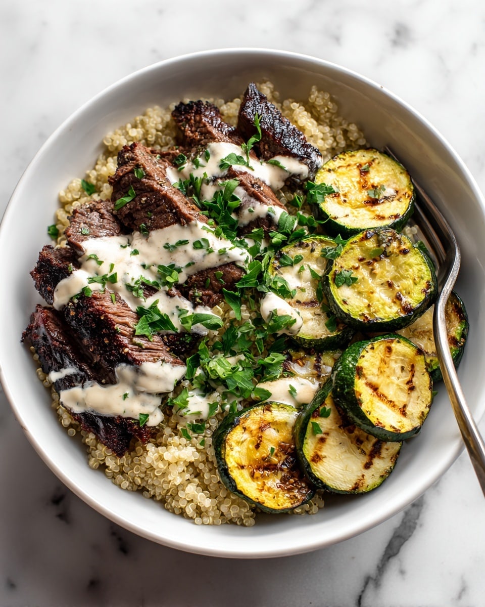 A white bowl filled with a base layer of light beige cooked quinoa with its tiny grain texture visible, topped with thick slices of grilled steak that are dark brown with seared grill marks, drizzled with a creamy white sauce and sprinkled with fresh green chopped parsley. On the right side, there are several grilled zucchini slices showing a vibrant green skin and pale yellow insides with dark grill lines, also garnished with parsley. A silver fork is resting inside the bowl on the right side. The bowl is placed on a white marbled surface. photo taken with an iphone --ar 4:5 --v 7